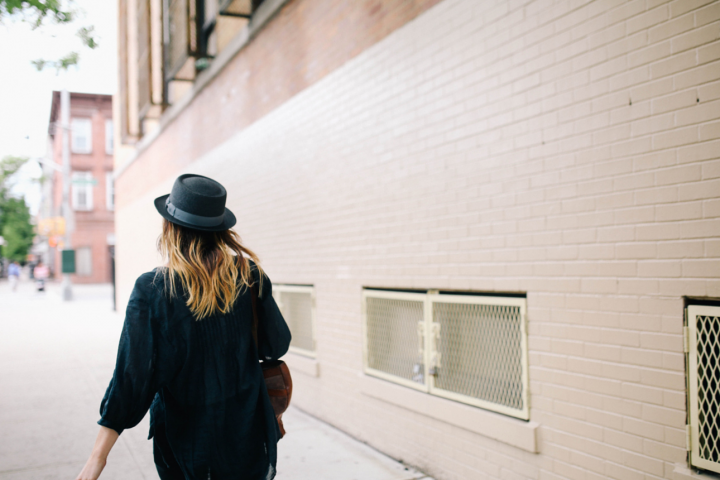 Girl in black hat walking through the street